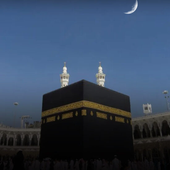 The Kaaba in Makkah with a crescent moon in the sky