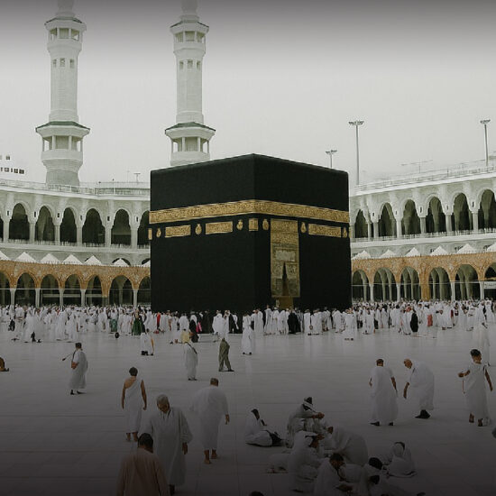 Wide-angle view of the Grand Mosque in Makkah crowded with pilgrims in white Ihram, focusing on the Kaaba and the spiritual atmosphere of Hajj 2025.