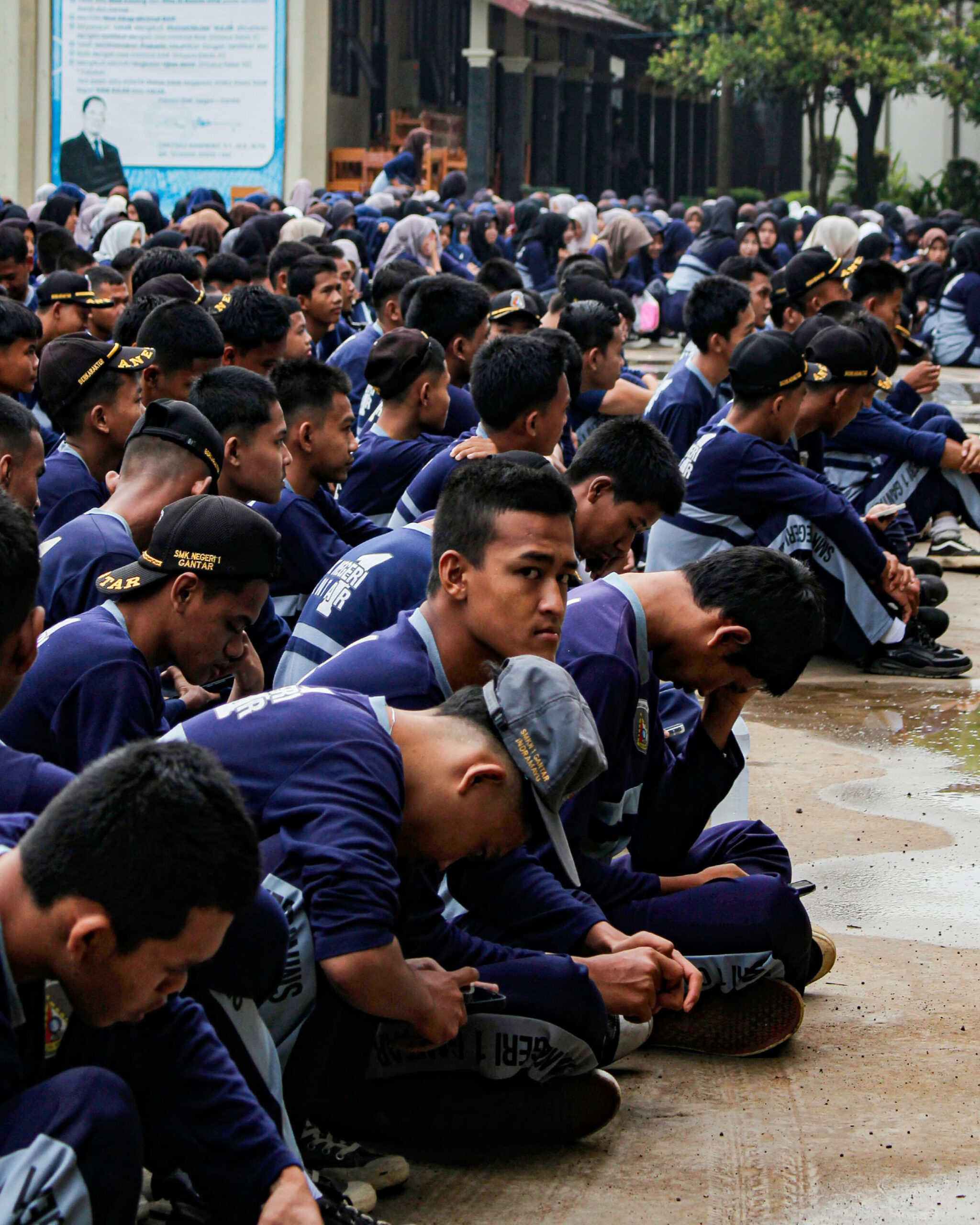 Students in uniform completing registration forms in a school courtyard during Punjab board’s Class 9 admission process.