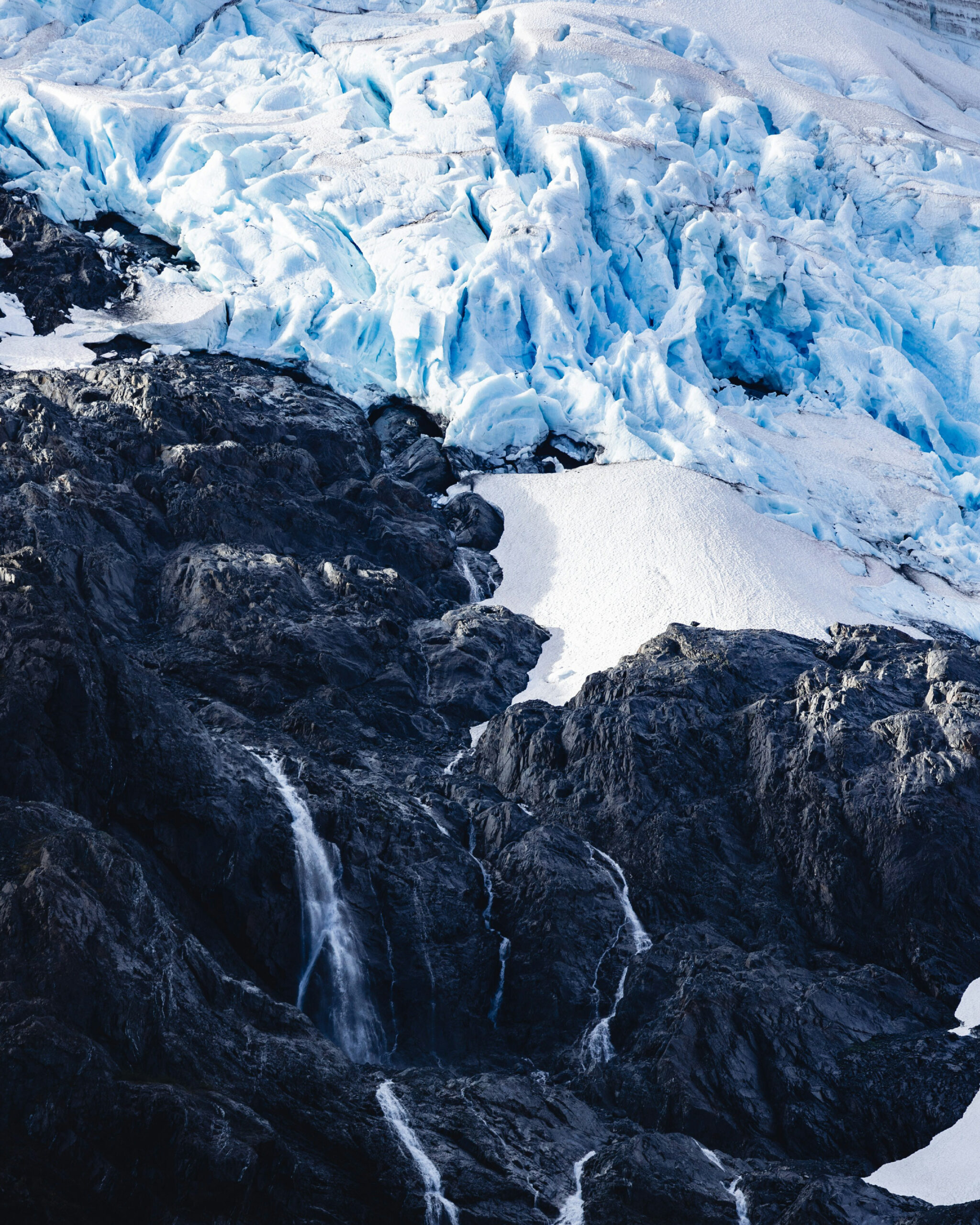 Tourists walking near a glacier in Naran Valley, wearing safety gear and passing warning signs, highlighting the importance of safety in Pakistan’s northern regions