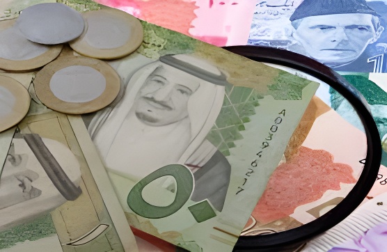 Saudi Riyal and Pakistani Rupee notes on a counter with a digital display of current exchange rates, representing the SAR to PKR market on June 3, 2025