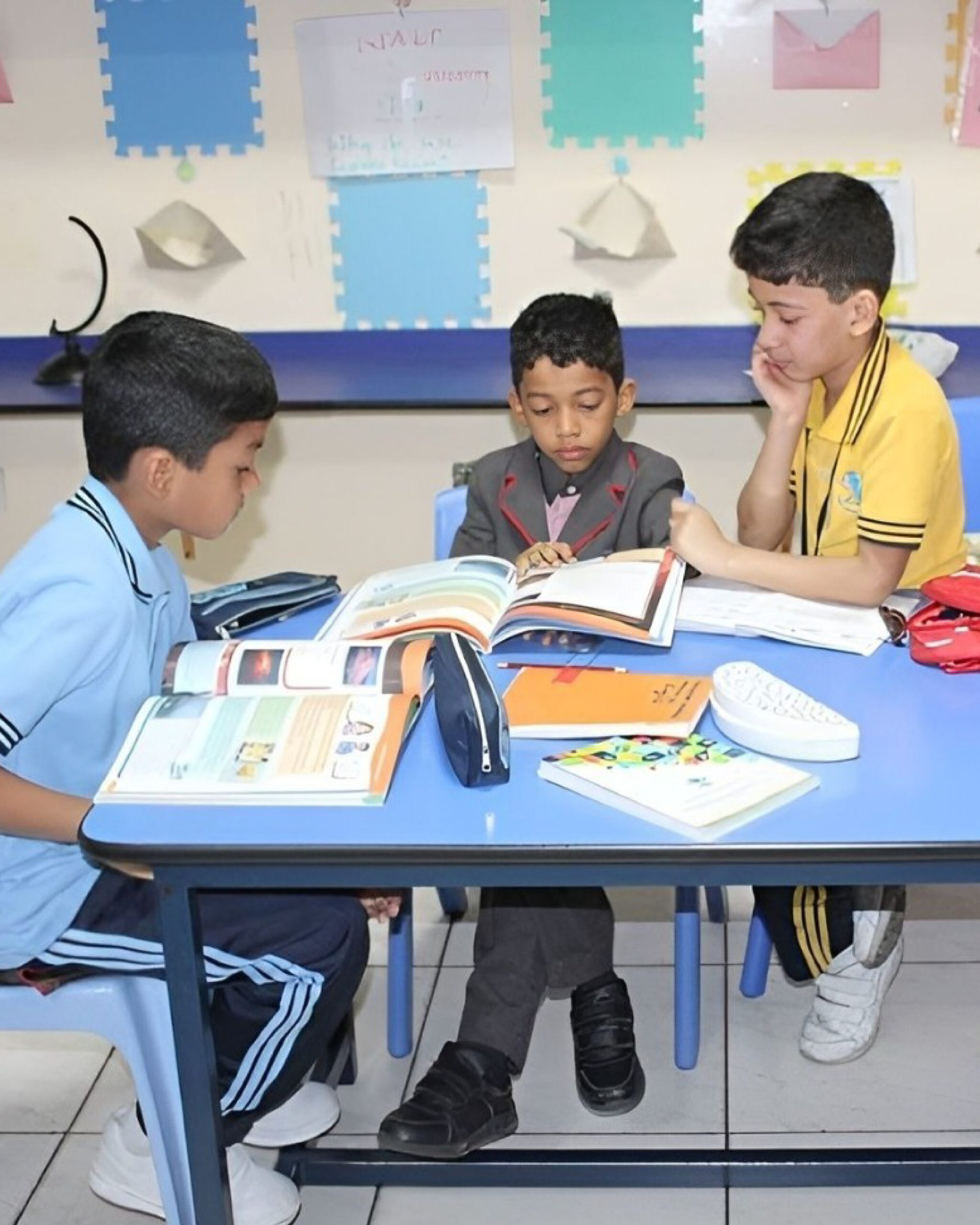 Students in an Islamabad classroom on the first day after summer vacation, with books open and a calendar highlighting the reopening date