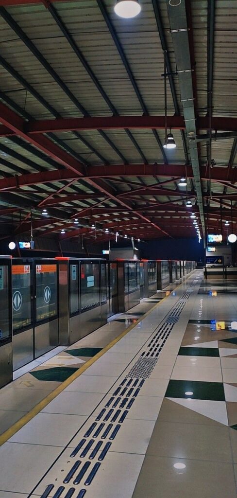 Modern train at Lahore station with passengers boarding and digital displays.