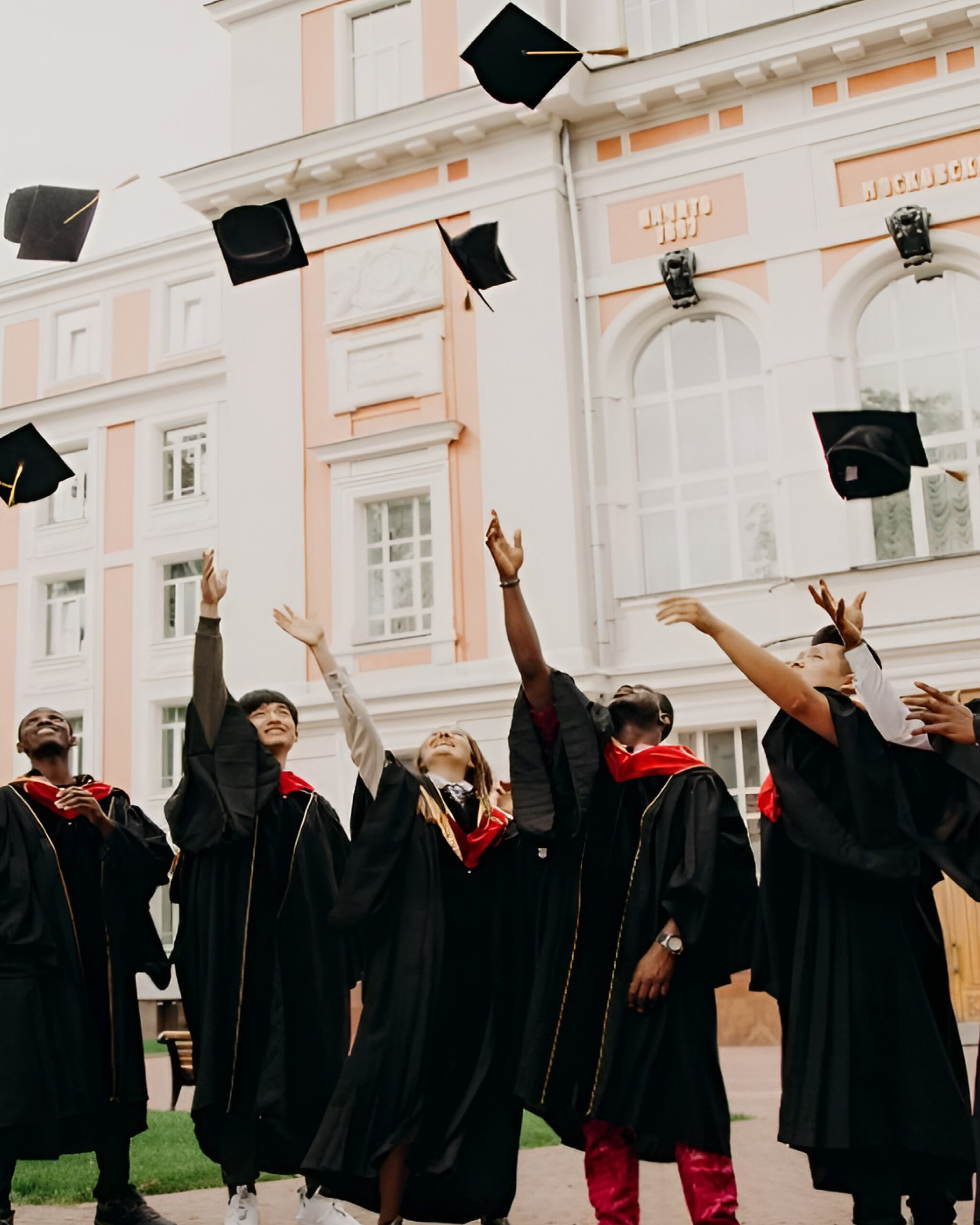 International students celebrating graduation in front of a historic German university as DAAD scholars