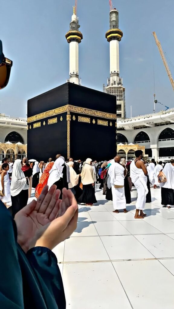 Pakistani pilgrims in Ihram at the Grand Mosque in Makkah, with the Clock Tower in the background, symbolizing unity and faith.