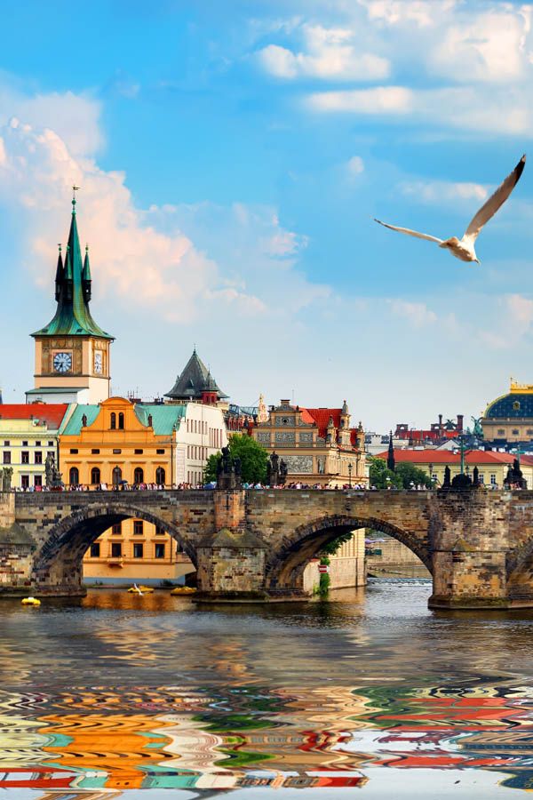 Sunset over a European city with historic buildings and a river, representing Golden Visa property investment opportunities.