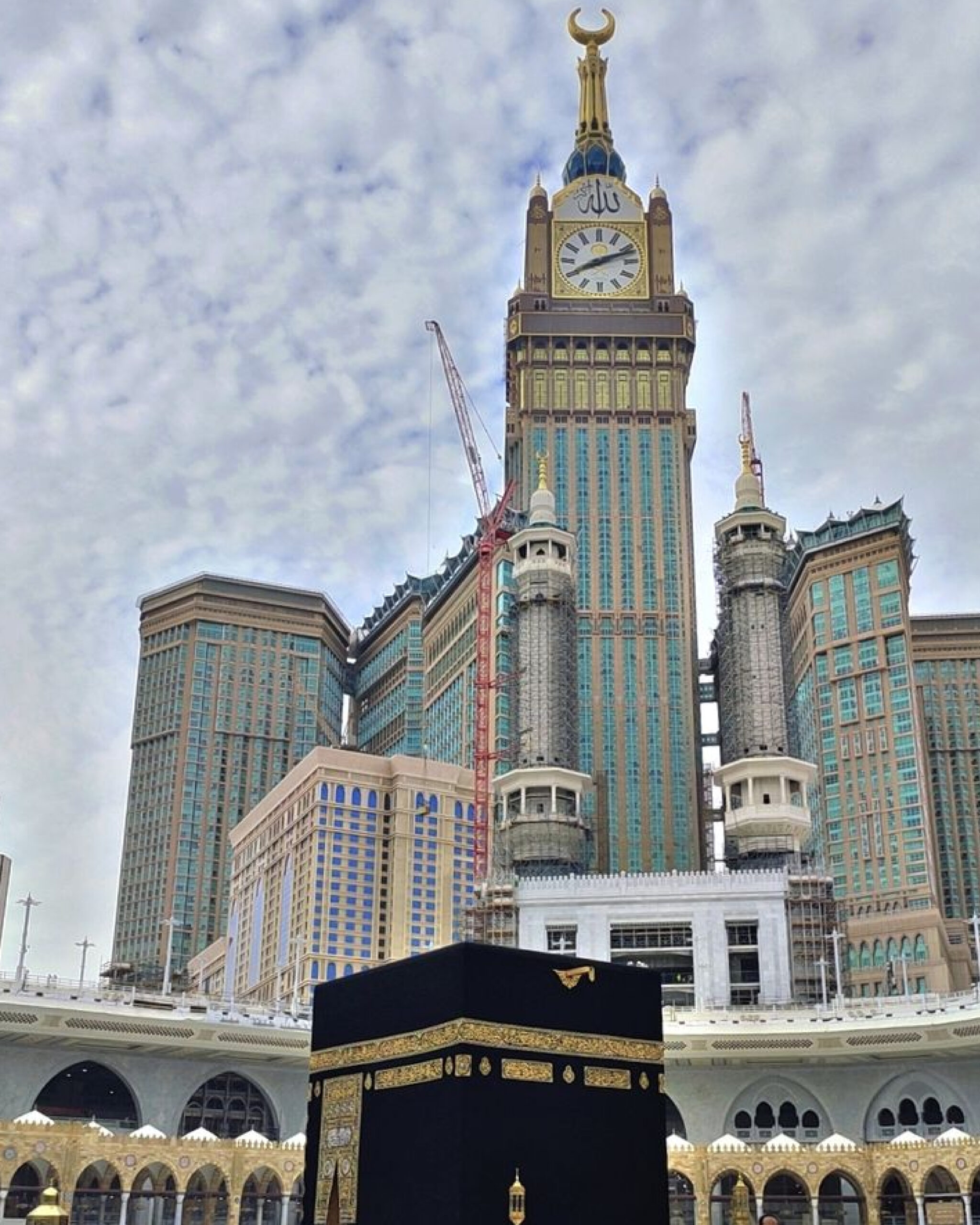 Pakistani pilgrims in Ihram at the Grand Mosque in Makkah, with the Clock Tower in the background, symbolizing unity and faith.
