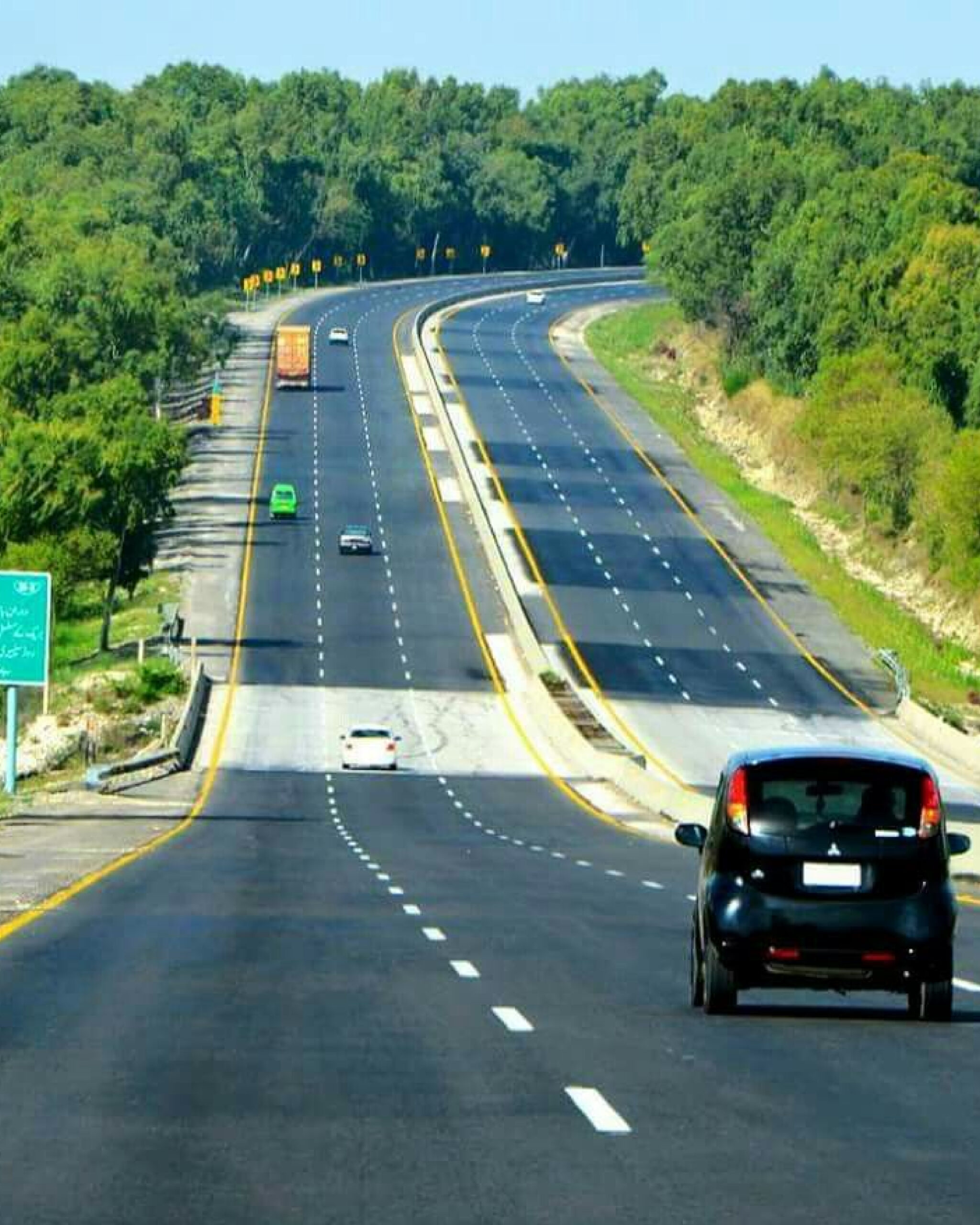 Lahore–Raiwind Motorway with vehicles in motion, green belts, and city skyline, illustrating Punjab’s modern infrastructure.
